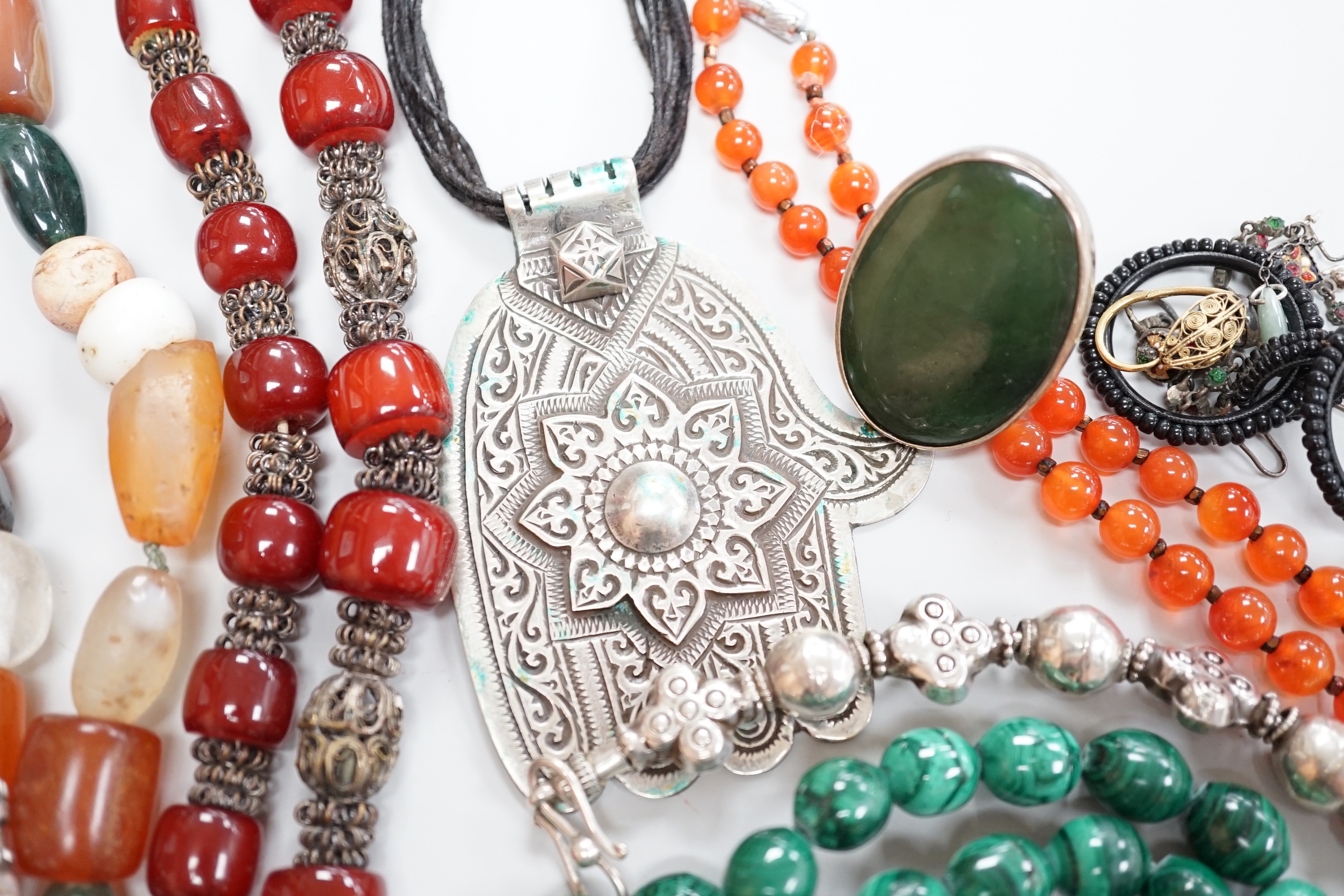 Assorted jewellery including a South American? white metal fringe necklace, a malachite bead necklace, amber earrings, filigree earrings, jet earrings, Hand Of Fatma pendant, agate bead necklace, hardstone pebble necklac